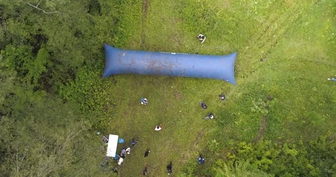 Competitors try to jump over a big obstacle. Aerial view, 4K. Stock Footage 124042277