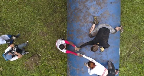 Competitors try to jump over a big obstacle. Aerial view, 4K. Stock Footage 124042623