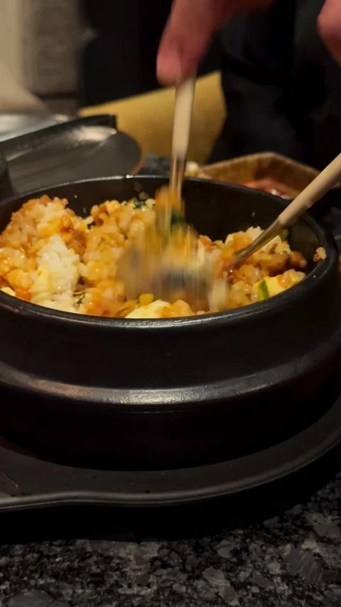 Compilation of Korean BBQ dining experience showing pouring sauce on bibimbap, Vidéo 337462159