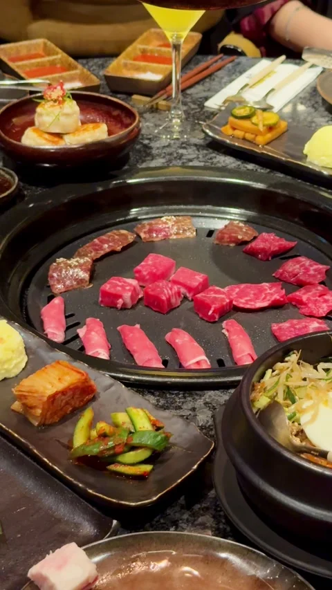 Compilation of Korean BBQ dining experience showing pouring sauce on bibimbap, Stock Footage 337462173