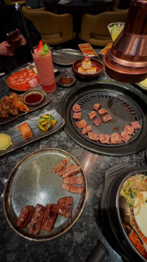 Compilation of Korean BBQ dining experience showing pouring sauce on bibimbap, Stock Footage 337462191