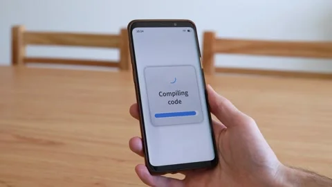Compiling code with your smartphone. Concept of doing software developing with Stock Footage 321357908