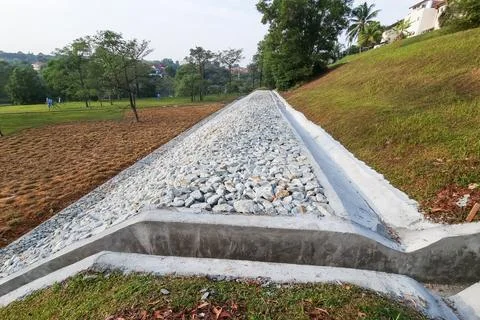Completed slope retention construction design with rocks and mesh to manage Stock Photos