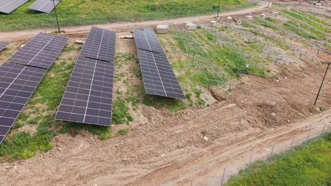 Completed solar panels beside incomplete mounting stands downward orbit aerial Vídeos de archivo 330933687