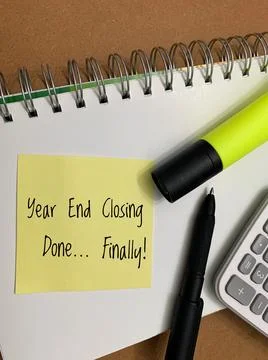 Completed year end closing text on sticky pad with calculator, highlighter and Stock Photos