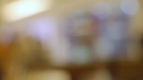 Completely blurred indoor restaurant or cafe interior creating a warm bokeh back 스톡 동영상 323231615