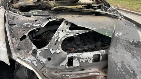 A completely burnt and destroyed car stands on the street Stock Footage 265164173