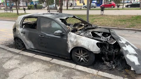 A completely burnt and destroyed car stands on the street Stock Footage 265164174