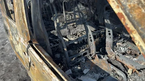 A completely burnt car after a fire, standing on the street Stock Footage 330172265