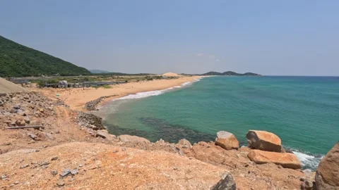 Completely empty wild beach with no people, clear water, yellow sand, rocks Video stock 248812821