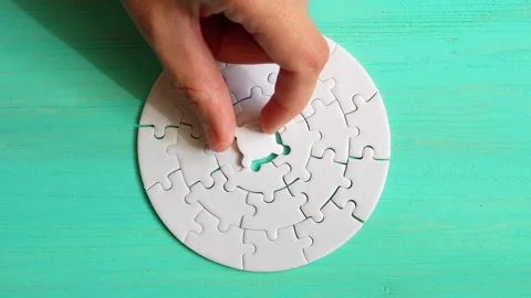 Completing Circular Puzzle on Teal Surface Stock Footage 295113794