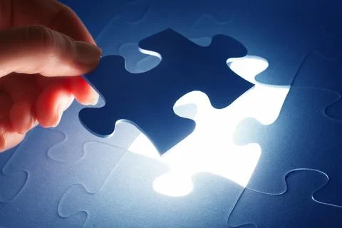 Completing the last piece of jigsaw puzzle. Solution, solving the problem. Fotos de archivo