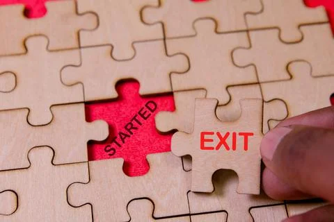 Completing a puzzle with exit piece on red background Stock Photos
