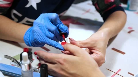 Completion of varnishing of nails with red lacquer Stock Footage 90410973