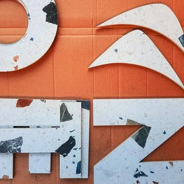 Complex cutting of letters and geometric shapes from ceramic tiles Stock Photos