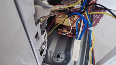 Complex electrical wiring inside an open microwave oven repair project Stock Photos