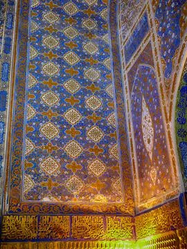 Complex geometric patterns and arabic calligraphy decorate the wall and cei.. 스톡 사진