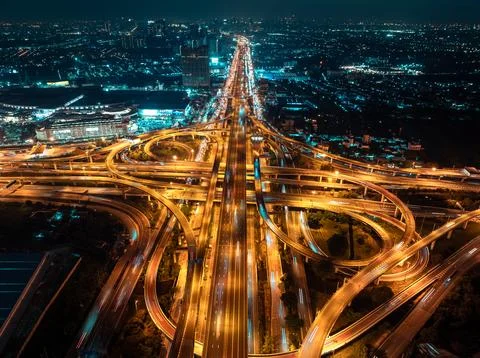 Complex Highway Interchange Illuminated By Traffic Light Trails At Night In.. Foto stock
