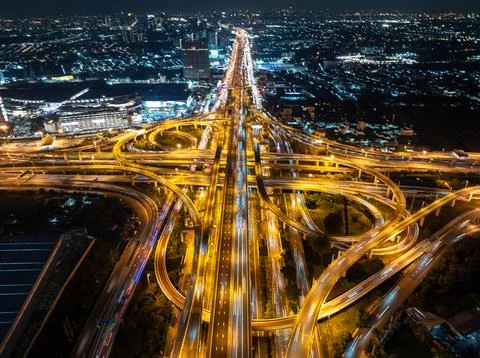 Complex Highway Interchange Illuminated By Vehicle Light Trails At Night Hi.. Stock Photos