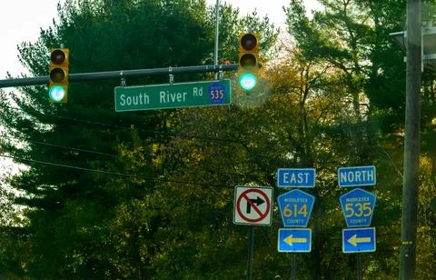 A complex intersection with several road signs and traffic lights. Stock Photos