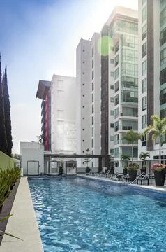 Complex of luxury buildings, with pool amenity, lounge chairs, planters with Foto stock