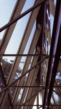 A complex metal framing structure and angled glass panels of a modern buildin Stock Photos