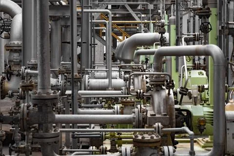Complex network of industrial pipelines, valves, and machinery inside a chemical Stock Photos