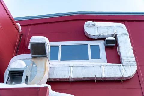 A complex network of large metal ducts and fans attached to wall. Stock Photos