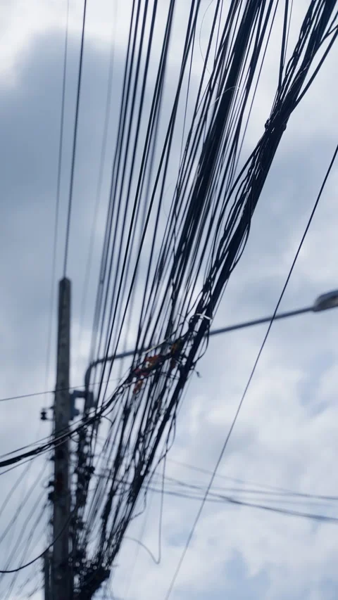 A complex network of overhead electrical and communication wires tangled around Stock Footage 312203617