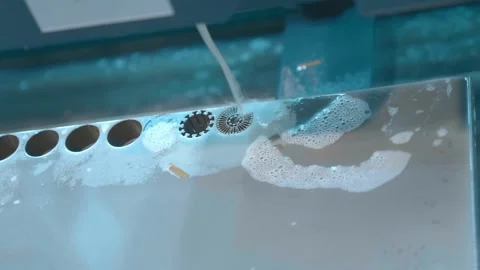 A complex part is cut out of a metal workpiece using a wire EDM machine Stock Footage 333387677