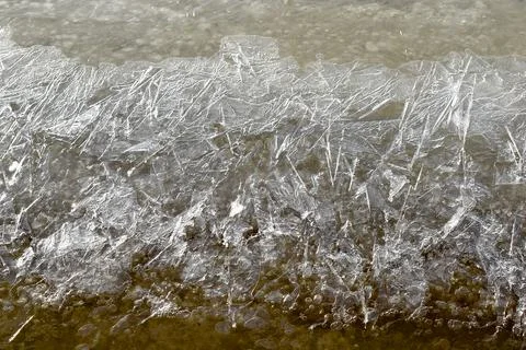A complex pattern formed by coastal ice on a river. Background. Stock Photos