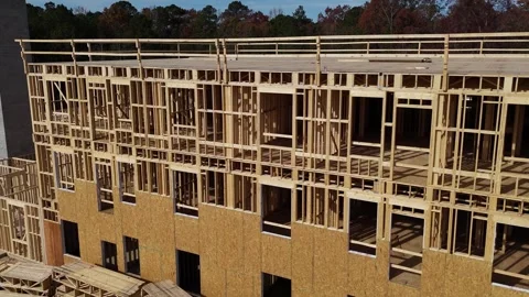 The complex process of wooden construction of a residential building skeleton in Stock Footage 306019558