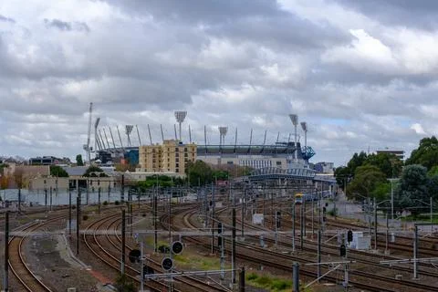 Complex railway infrastructure leading towards a massive sports stadium und.. Stock Photos