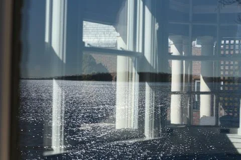 Complex reflection of ocean wave patterns in an old window Stock Photos