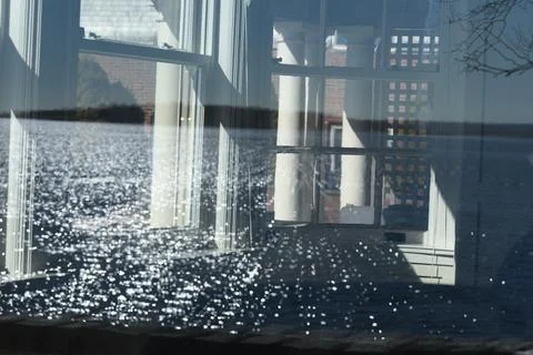 Complex reflection of wave patterns in an old window is lovely and peaceful Stock Photos