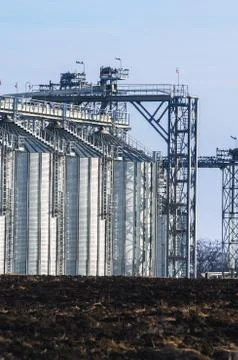 The complex silo installations for the storage of grain standing in the plowed Stock Photos