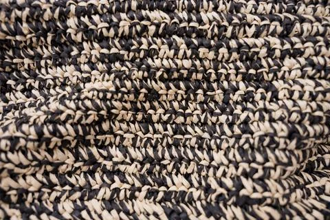 Complex texture of woven raffia bag in black and beige straw color Stock Photos