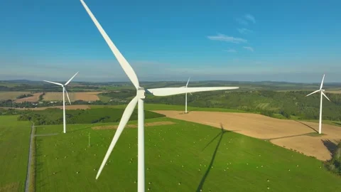 A complex of  wind power plants with spinning propellers in a hilly landscape. Stock Footage 233835741