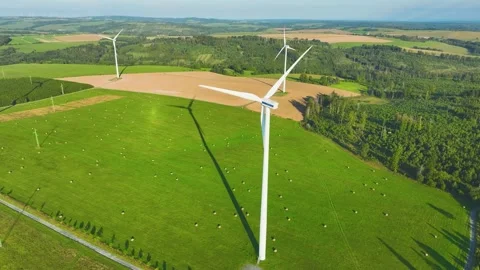 A complex of  wind power plants with spinning propellers in a hilly landscape. Stock Footage 233835990