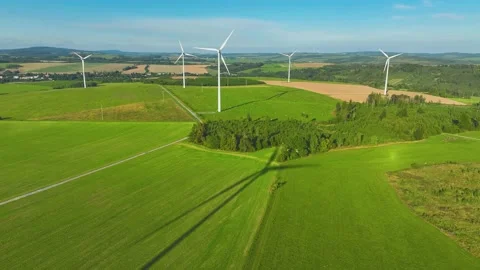 A complex of  wind power plants with spinning propellers in a green countryside. Stock Footage 233836074
