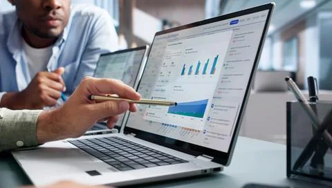 Compliance Officer Analyzes Risk Data On Laptop For Audit Review. Stock Photos