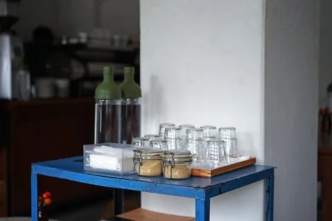 Complimentary self serve table stand of water, napkin tissue and sugar Stock Photos