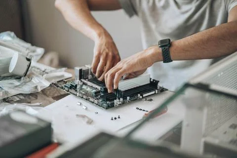 Component Connection : A close-up of hands meticulously assembling a desktop's Stock Photos