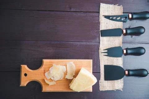 Composed Flat lay detail view of aged cheddar cheese with cheese knife set, o 스톡 사진