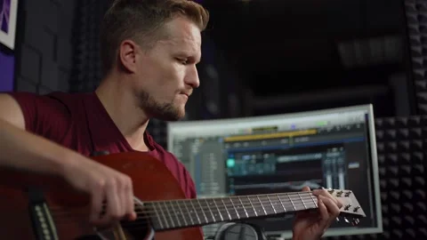 Composer playing guitar and singing in recording studio Video stock 142401462