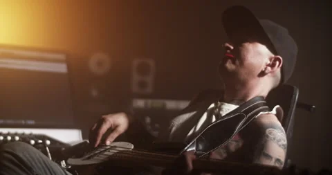 Composer playing guitar while creating music in studio Stock Footage 249912860