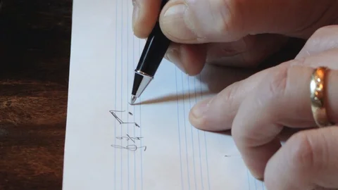 Composer writing music notes on sheet with pen hand close up Stock Footage 106224520