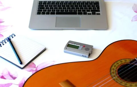 Composer's work table. Top view of guitar, notepad, computer and tuner on the Stock Photos