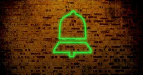 Composite of digital green notification bell icon glowing against old brick Stock Photos