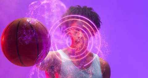 Composite of illuminated circular and abstract pattern over biracial basketball 스톡 사진